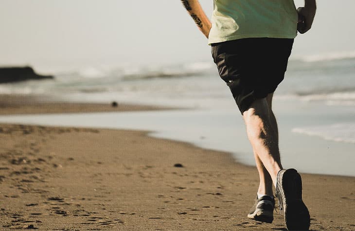 Man Running On Beach To Show How Physical Fitness Can Affect Addiction Treatment