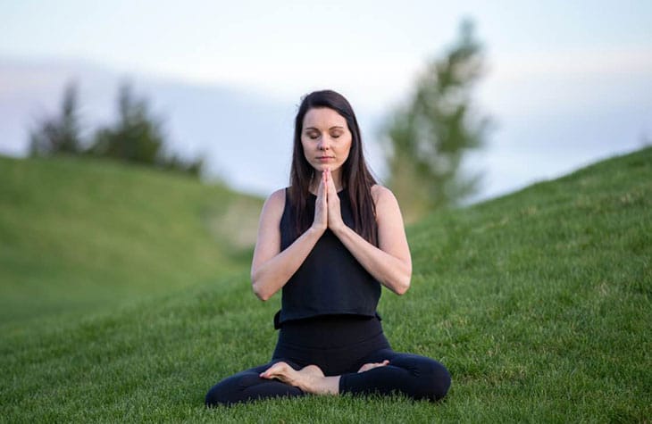 Woman Meditation In Grass Field As Part Of Her Mindfulness And Addiction Recovery Treatment