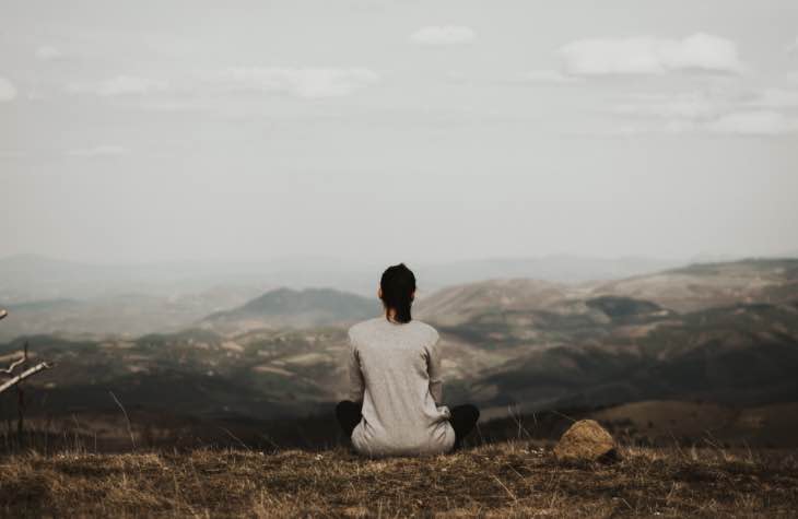 Woman Sitting Peacefully Overlooking Mountains To Depict The Types Of Treatment Programs Available For Opioid Addiction