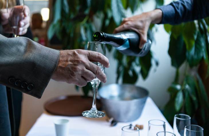 Person Pouring Drink Into Glass To Symbolize Drinking Alcohol