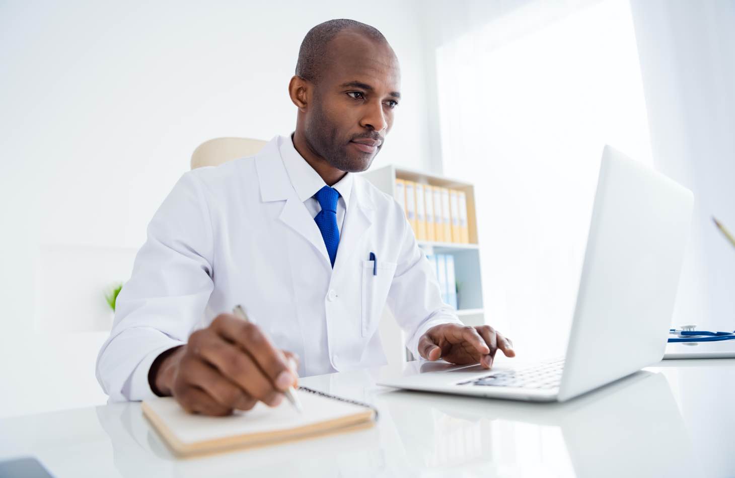 A Doctor On His Laptop Looking Up Medication Assisted Treatment Options For A Client