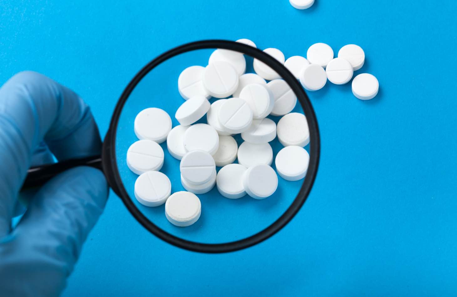 A Magnifying Glass On Pills, Similar To Medication Assisted Treatment Pills