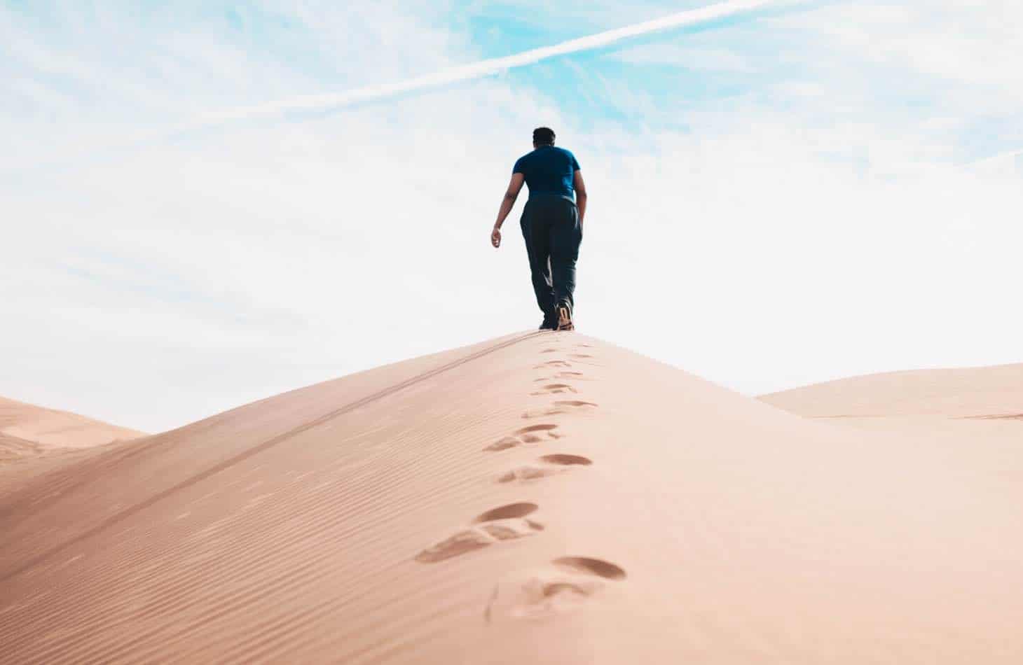 A Man Walking In A Desert Representing The Journey Of Sobriety And Medication Assisted Treatment