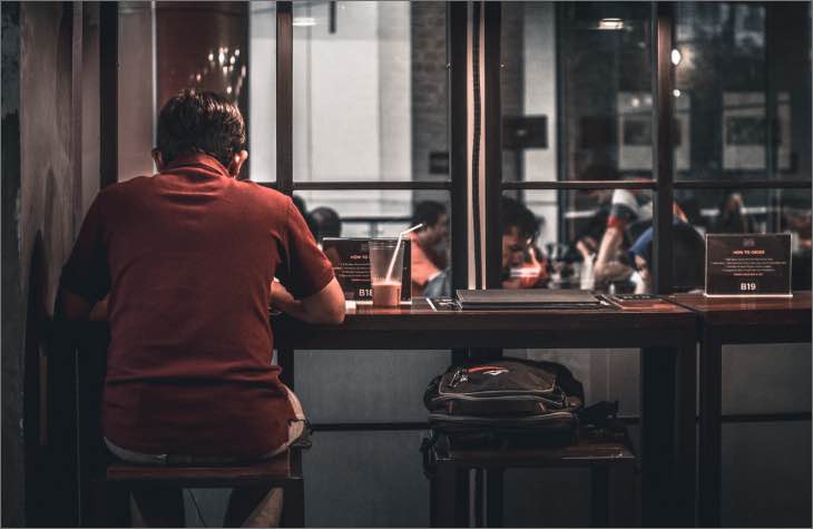 Person Sitting At Bar Struggling With An Alcohol Addiction