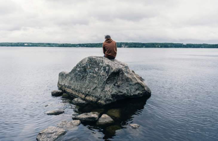 Person Sitting On Rock Symbolizing The Lonliness People Feel Prior To Addiction Treatment