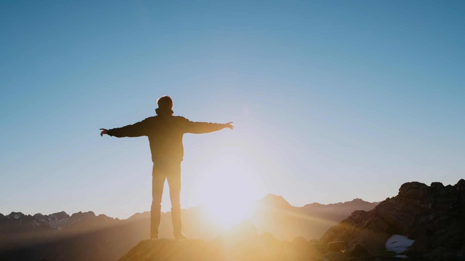 Young Man Atop Mountain Facing Sun Rise On Does Rehab Work Blog