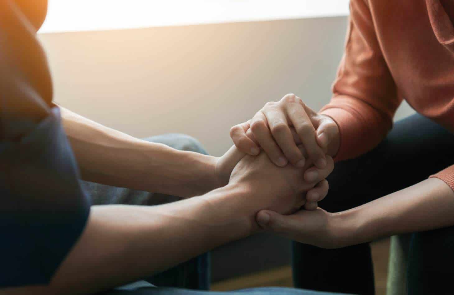 Friends Holding Hands As They Work To Overcome Negative Alcohol Abuse Effects