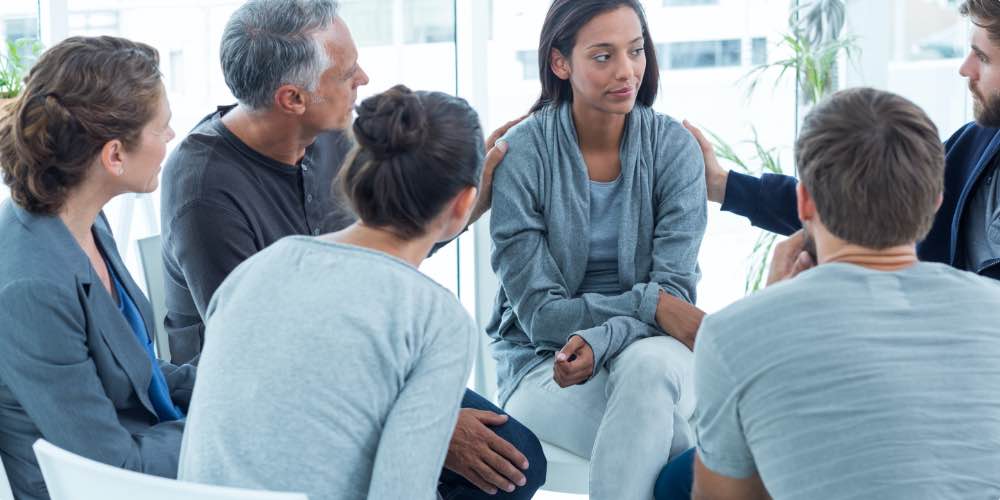 Group Comforting Each Other In Opioid Detox Aftercare