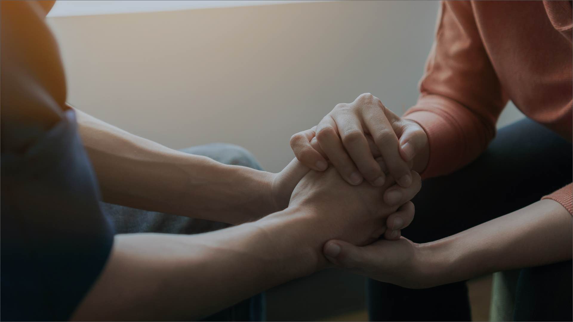 Two people holding hands discussing how to find the best rehab center
