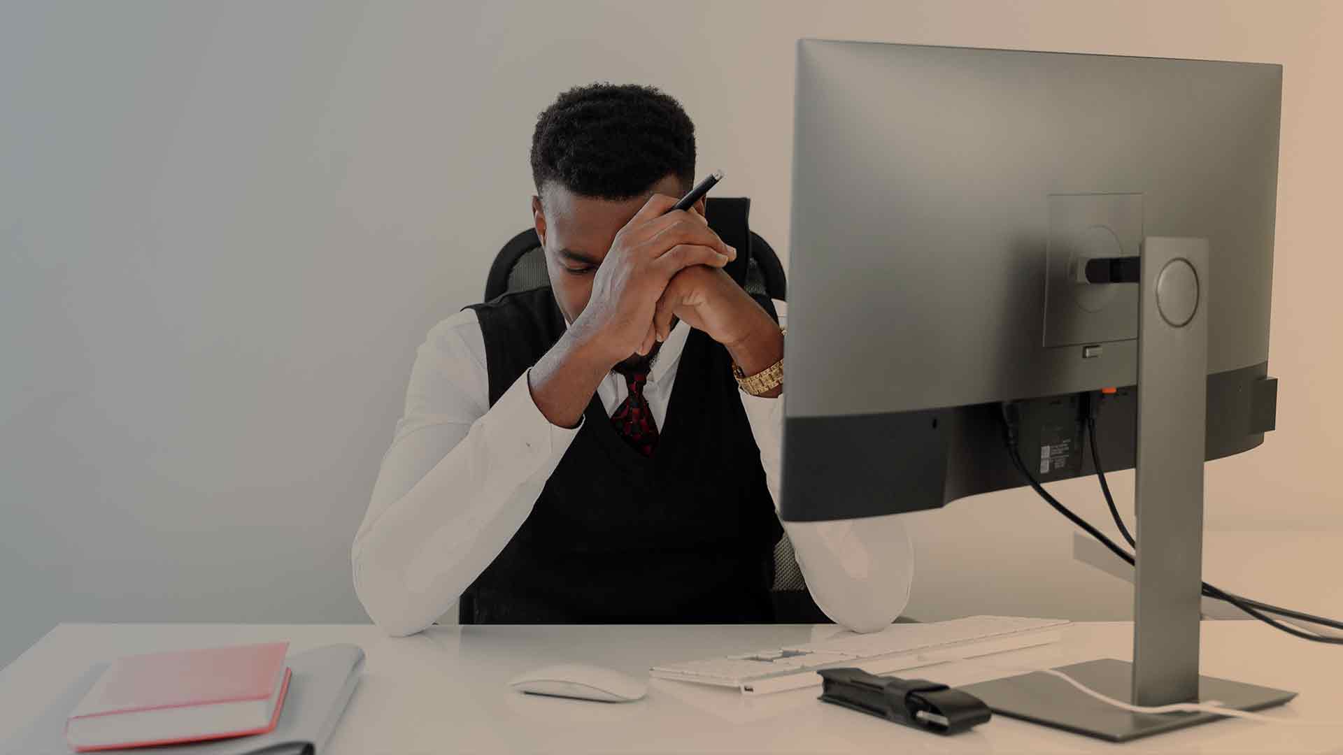 african american man overwhelmed at work dealing with high functioning alcoholism