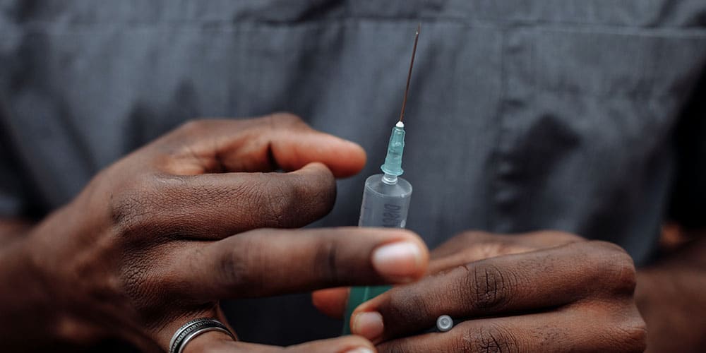 a man is holding a prepared needle for injection