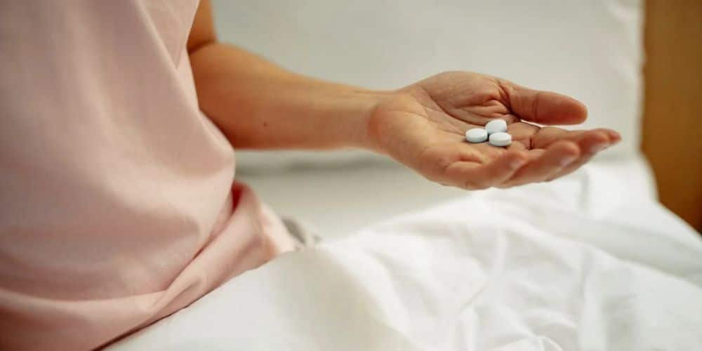 Photo Of A Person Holding White Tablet In Palm Of Hand