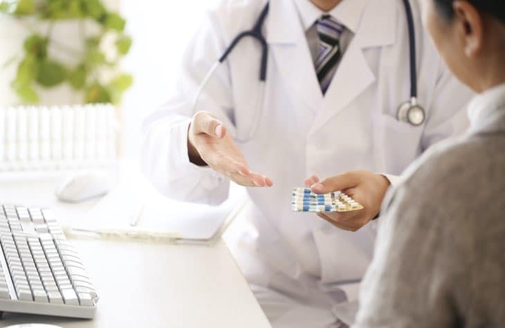 Doctor handing client medication to be used as therapy