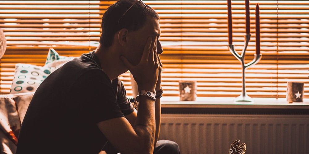 photo of a man sitting and having a hard time because of dizziness