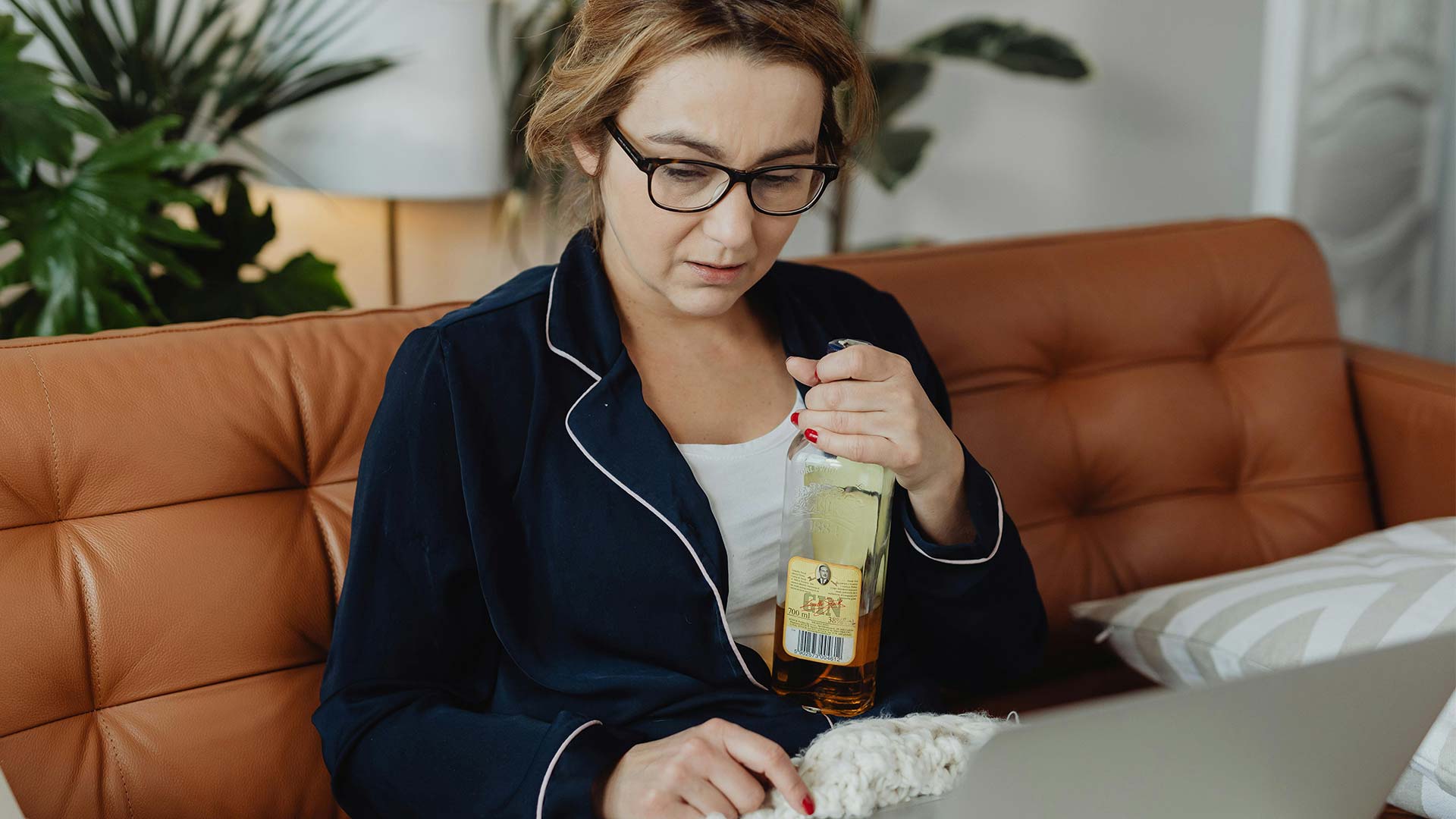 a woman in blue sleepwear holding a liquor