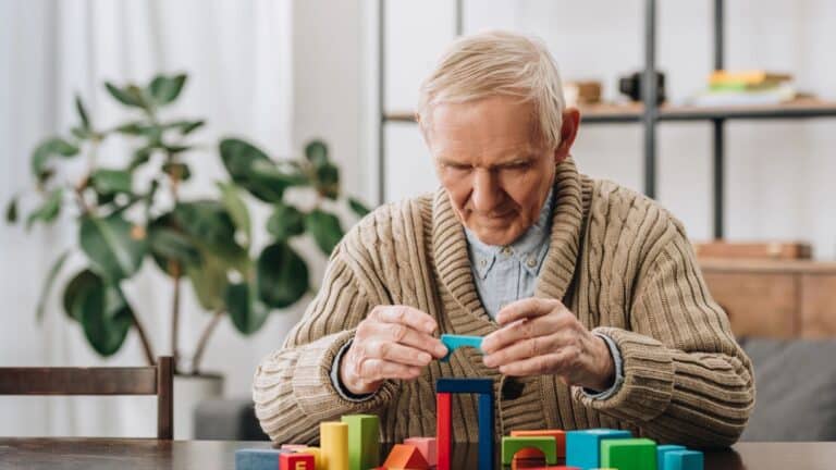 senior man playing wooden shapes