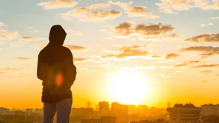 man sitting on the edge of high roof