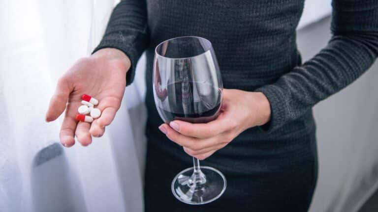depressed woman with wine glass and pills