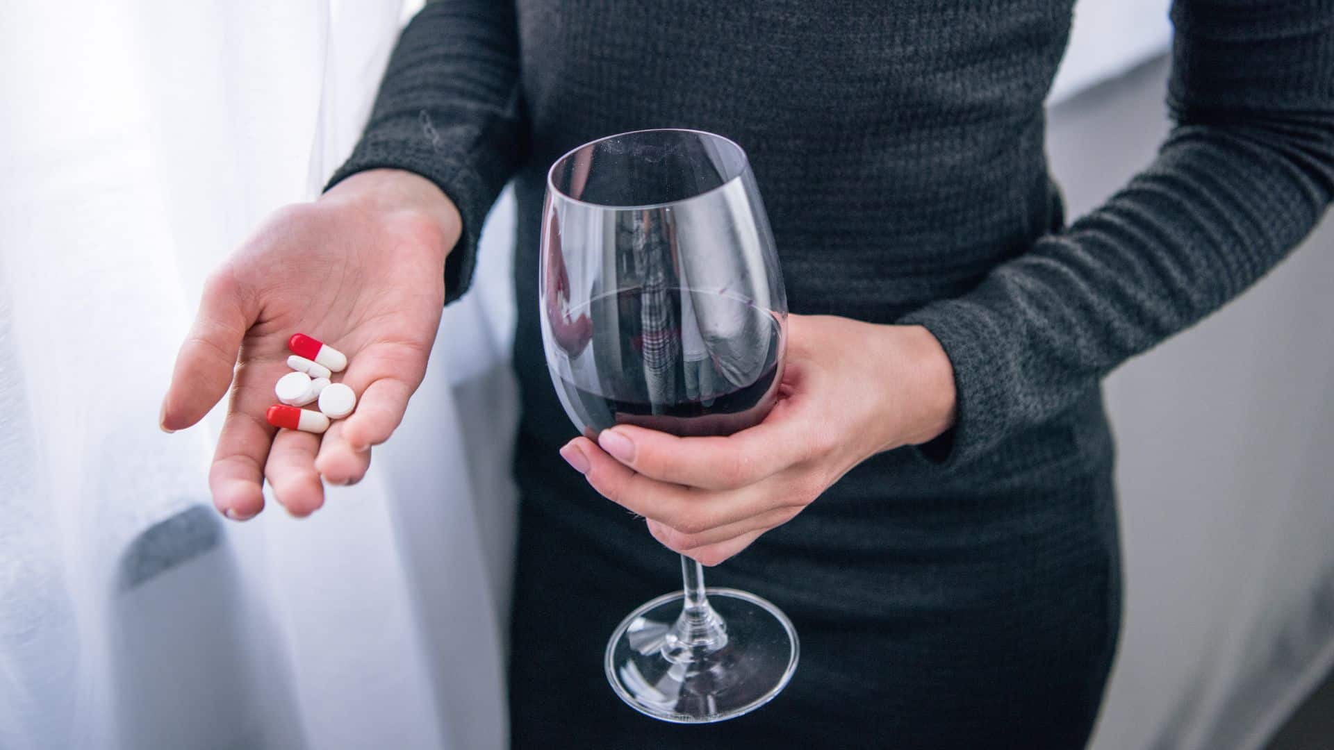 depressed woman with wine glass and pills