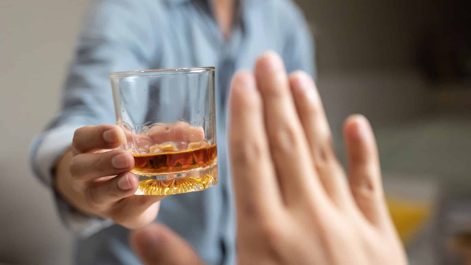 Person deny alcohol drink from his friend