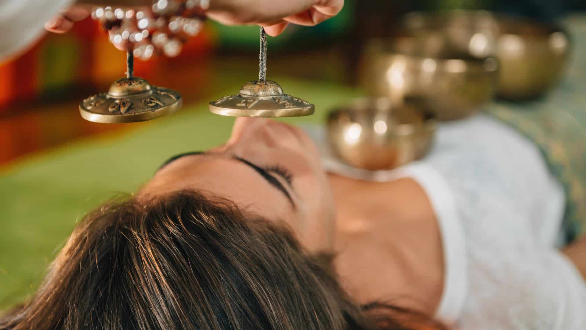 Woman using Tibetan bells in sound therapy