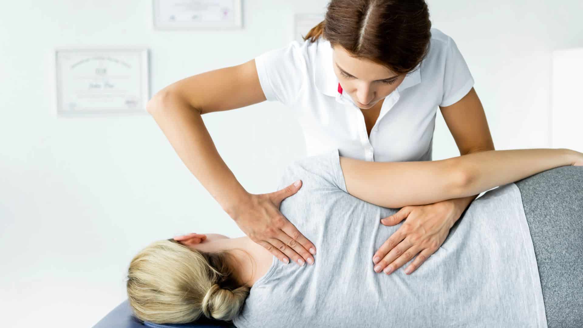 chiropractor touching hand of patient